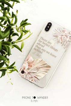 a phone case with an image of a bird and flowers on it next to a potted plant