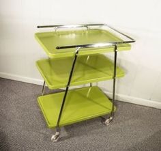 a lime green serving cart with two shelves on each side and one shelf underneath the tray