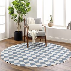 a chair sitting on top of a wooden floor next to a potted plant