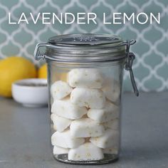 a jar filled with marshmallows sitting on top of a counter next to lemons