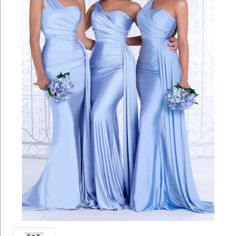 three bridesmaids in blue dresses posing for the camera with their bouquets on