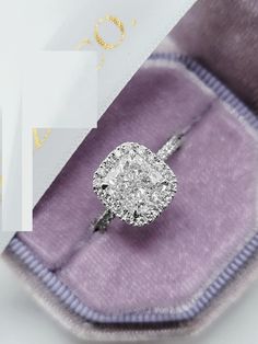 an engagement ring with a cushion - cut diamond sits in a velvet box, next to the word love written on it