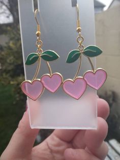 Handmade drop earrings using pink and green enamel cherry heart shaped charms with gold base, finished with gold ear wire hooks as closure. The cherry heart also have a slight glittery tint. Perfect for Valentine's day! Indie Girls, Indie Jewelry, Earrings Aesthetic, Cherry Earrings, Fruit Earrings, Funky Earrings, Retro Earring, Heart Dangle Earrings, Dangly Earrings