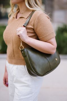 You've been looking for a stunning purse, and you have found it! Made from buttery-soft vegan leather and glossy gold hardware, the Marissa Crossbody is the epitome of quiet luxury. This stunning saddle bag transforms seamlessly from a handbag to a crossbody thanks to two interchangeable straps. You'll adore the versatility this bag offers! Details: 11" long x 9" height x 3.5" wide Vegan leather The detachable shorter chain strap is 24" long The detachable longer vegan leather strap adjusts from Modern Crossbody Saddle Bag With Magnetic Closure, Green Crossbody Saddle Bag With Adjustable Strap, Olive Crossbody Bag With Detachable Strap, Daily Use Crossbody Vegetable-tanned Saddle Bag, Leather Saddle Bag With Belt Loops, Crossbody, Convertible Bags, Clear Bags, Modern Chic, Jewelry Case