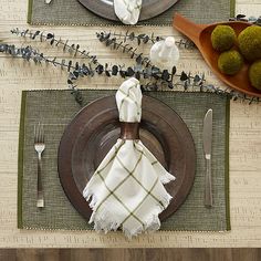 a place setting with napkins, plates and silverware