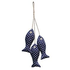 three blue fish hanging from a rope on a white background with polka dotty fabric