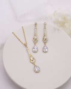 Complete your bridal look with this stunning wedding jewelry set. The sparkling cubic zirconia stones delicately accentuate the bride's natural beauty, adding a touch of elegance and glamor. Featuring an art deco style design, this bridal jewelry set features CZ teardrops accented with a filigree pattern. DETAILS * High quality cubic zirconia.  * Earrings measure 2 inches long. * Necklace is adjustable from 16 inches to 18 inches long, pendant (including bail) measures 2 inches. * Perfect for brides, bridesmaids, prom, or any special occasion. Optional custom cards available for gift giving! * Optional bracelet measures 7 inches long. * Finish: silver, gold or rose gold. * Hypoallergenic, lead-free & nickel-free. SHIPPING * Leaves our facility within 1-3 business days. * Shipping upgrades Elegant White Jewelry Sets For Brides, White Cubic Zirconia Bridal Accessories For Wedding, Dazzling Diamond-accented Jewelry Sets For Wedding, Dazzling Diamond Accented Jewelry Sets For Wedding, Elegant Crystal Bridal Sets For Bride, Wedding Jewelry Sets With Sparkling Cubic Zirconia, Diamond White Cubic Zirconia Jewelry Sets For Wedding, Elegant White Bridal Set, Elegant Crystal Bridal Set For Anniversary