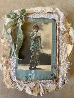 an old photo frame with a green ribbon around it