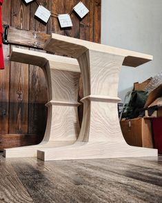 a wooden table sitting on top of a hard wood floor next to a book shelf