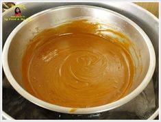 a metal bowl filled with sauce on top of a stove