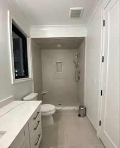 a bathroom with a toilet, sink and mirror