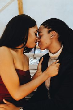 two people are kissing each other in front of a piano