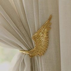 gold angel wings hang on the curtain