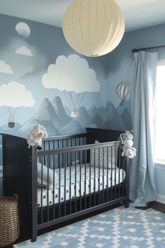 a baby's room decorated in blue and white with hot air balloons