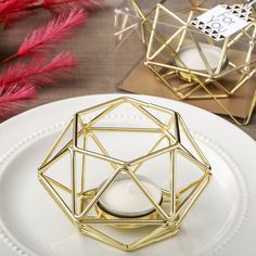 a white plate topped with a gold geometric candle holder