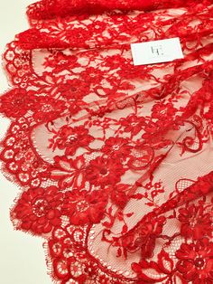 red lace with small flowers on it and a price tag attached to the bottom of one piece