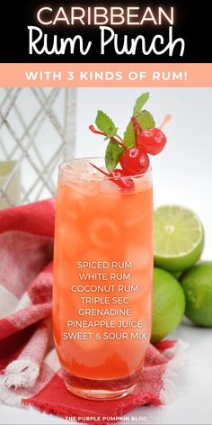 a drink in a glass with limes and cherries on the rim next to it