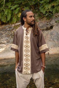 Behold our MAHADI top, a Ceremonial Shamanic Shirt, a one-of-a-kind garment that brings a touch of cultural tradition to any occasion. Made from natural cotton, this loose-fit shirt is both comfortable and environmentally friendly. The tribal patterns are block printed by hand, giving each shirt a unique and authentic look. The V-neck design and coconut button closure add a touch of sophistication, making this shirt perfect for boho or alternative weddings as well as other gatherings and ceremon Hippie Outfits Men, Summer Hippie Outfits, Bohemian Outfit Men, Mens Kimono Jacket, Ritual Clothing, Mens Poncho, Hemp Clothing, Festival Pants, Loose Fit Shirts