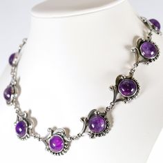 "Los Castillo Amethyst Necklace | Sterling Silver Vintage Jewelry | Mid-Century Taxco Mexico Crafted from sterling silver and featuring amethyst cabochons, this necklace showcases the exceptional artistry of the esteemed Los Castillo Taxco workshop. It consists of eleven panels, each graced with a nicely matched amethyst cabochon, making up a 14.5\" necklace that exudes timeless artistry. Marked with the Los Castillo hallmark dating from 1950 to 1965, this exquisite and highly coveted piece is a must-addition for collectors with discerning tastes. PRODUCT SPECIFICATION Product Type: Vintage  Maker: Los Castillo          Hallmarks: Los Castillo and Taxco encircling Eagle 15 Mexican assayer's mark, Made in Mexico and Sterling in a circle (1950-1965), 695 Materials: 925 Sterling Silver Gem or Formal Amethyst Jewelry With Polished Finish, Elegant Purple Jewelry With Polished Finish, Formal Purple Jewelry With Polished Finish, Fine Jewelry Purple Cabochon, Vintage Amethyst Jewelry With Polished Finish, Classic Polished Amethyst Jewelry, Classic Amethyst Jewelry With Polished Finish, Fine Amethyst Jewelry With Polished Finish, Purple Sterling Silver Necklace With Polished Finish