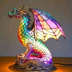 a colorful dragon lamp sitting on top of a wooden table