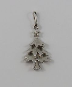 "This is a vintage \"Christmas Tree\" charm for a charm bracelet.  It weighs 1.80 grams and measures 5/8\" x 1 1/8\", tested NOT SILVER All charms come with a split ring to attach to a bracelet. We have hundreds of charms in stock. If you don't see what you are looking for in our shop please contact us as it is likely we have it. Inventory #9623 *Not Silver category consists of sterling silver that is rhodium plated, nickel, zinc, copper, aluminum, iron and titanium charms*" Vintage Jewelry For Christmas Anniversary, Silver Hallmark Jewelry For Christmas, Collectible Silver Christmas Jewelry, Christmas Silver Hallmark Jewelry, Christmas Novelty Silver Jewelry, Silver Charm Bracelet For Christmas, Christmas Star Charm Jewelry, Christmas Festive Silver Charm Bracelet, Christmas Tree Vintage