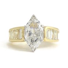 an oval cut diamond with three baguets on the side and shoulders, set in yellow gold