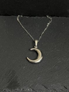 Crescent moon necklace hangs on stainless steel chain approx 18"