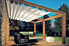 an outdoor living area with wood floors and white awning