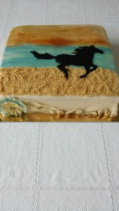 there is a cake that looks like a horse running on the beach in the sand