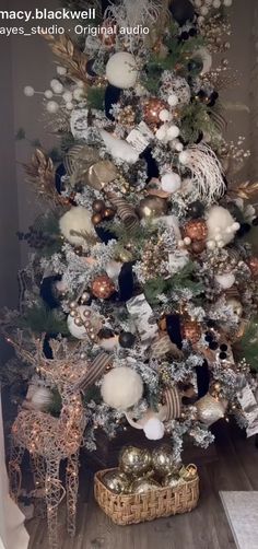 a white christmas tree with gold and silver ornaments