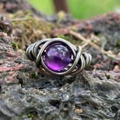 Amethyst ring made with non tarnish grey plated wire and a 6mm amethyst crystal that has been ethically sourced from a reputable supplier. Custom made to fit any USA size 4-14 including half and quarter sizes! Comes in a gift box. Amethyst is a purple stone, known as a "Gem of Fire" by ancient cultures. It was greatly sought after throughout history and at times valued as highly as Diamonds. Today, this semi-precious variety of quartz is found in many locations around the world. The presence of Manganese in the stone produces the purple hue, and variation of the amount of iron in the stone creates a color range from reddish purple to deep violet to light lilac. The name derives from the Greek word for "not intoxicated" and was once believed to prevent drunkenness and overindulgence.  Ameth Pisces Scorpio, Pisces And Scorpio, Iron Ring, Scorpio Sagittarius, Jewelry Crystal, Greek Words, Purple Stones, Ancient Cultures, Purple Hues