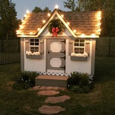 a small white house with lights on the roof