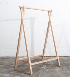 a wooden easel leaning against a white wall