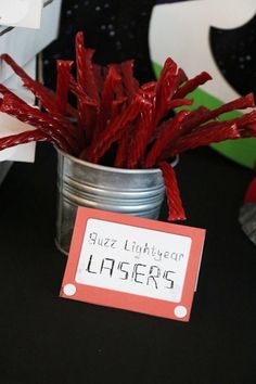 some red sticks are in a tin with a sign on it that says lazero