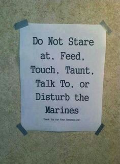 a sign posted on the wall stating do not stare at, feed, touch, talk to, or disturb the marines