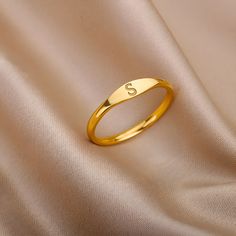 Our Initial Ring is a beautiful and elegant piece of minimalist jewelry, perfect for any occasion.  This tiny ring, available in either gold or silver, is the perfect gift for the special woman in your life. With a single initial featured prominently on the front, this ring is a subtle and sophisticated way to personalize your style.  Whether you are looking for a monogrammed piece to add to your collection or a simple, yet chic accessory to complete your outfit, this Initial Ring is sure to imp Ring Designs Simple Gold, Gold Simple Ring For Women, Gold Rings For Woman, S Letter Rings For Women, Gold Ring With Initials, A Ring Letter, Initial Rings For Ladies, Ring With Initials Letters, Minimal Ring Design For Women