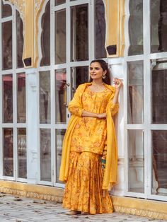 Yellow Floral Printed Cotton Silk Gharara Set now available at Trendroots Designer Yellow Palazzo Set With Printed Motifs, Traditional Sharara With Printed Motifs For Wedding, Sharara With Printed Motifs For Wedding And Navratri, Printed Motifs Sharara For Wedding And Navratri, Designer Yellow Kurta With Printed Motifs, Designer Wear Yellow Kurta With Printed Motifs, Yellow Sharara With Straight Kurta, Yellow Palazzo Set With Printed Motifs For Wedding, Wedding Yellow Palazzo Set With Printed Motifs