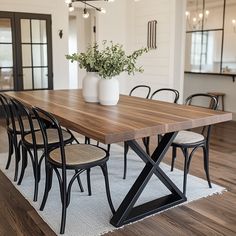 a dining room table with six chairs and a potted plant on the top of it