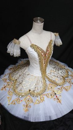 a white and gold ball gown on display