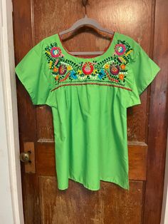 Gorgeous vibrant lime green embroidered blouse. Beautiful floral embroidery.  In great condition. Some loose threads along the hems, but nothing that impacts the structure.  No tags, but feels like cotton.  All measurements are listed in the final picture. Spring Bohemian Crew Neck Blouse, Green Embroidered Long Sleeve Tops, Green Long Sleeve Top With Floral Embroidery, Green Long Sleeve Tops With Embroidered Neckline, Green Long Sleeve Top With Embroidered Neckline, Floral Embroidered Tops For Spring Festival, Embroidered Crew Neck Blouse For Summer, Bohemian Green Top With Embroidered Hem, Bohemian Green Embroidered Hem Top