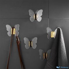 three butterfly shaped hooks hang on the wall