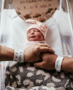 a person holding the hand of a baby