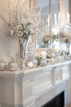 a fireplace mantel with candles, flowers and ornaments on it in front of a mirror