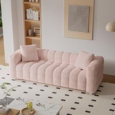 a pink couch sitting on top of a white rug