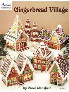 a group of gingerbread houses sitting on top of snow covered ground