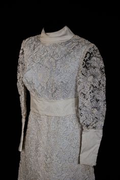 a white dress with long sleeves and flowers on it