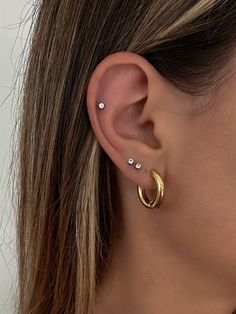 a close up of a person wearing an ear with two piercings on the side