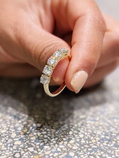 a woman's hand holding onto a diamond ring