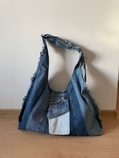 an old jean purse is sitting on the floor in front of a white wall and wooden floors