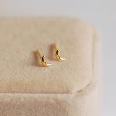 Shoot for the moon with these stunning Tiny Gold Crescent Moon Stud Earrings. The perfect present for someone special, or as a treat to yourself, these pretty earrings are very dainty. Made from gold-plated sterling silver, they can be worn every day and would look great as a second piercing. Your earrings will arrive beautifully gift wrapped in white tissue, in a Carriage Trade gift box, free of charge. Studs measure 5mm in length and come with butterfly backs. If you have any questions, please let me know.